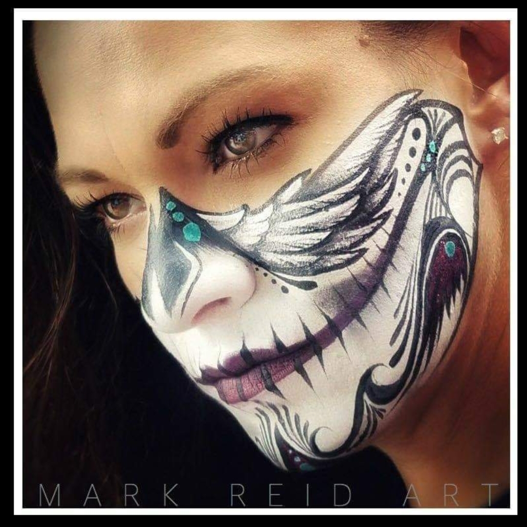 Beautiful woman with a face painting on her nose and around and mouth which resembles a skulls lower half